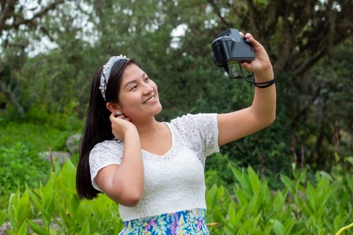 A shot of a girl with taking selfie with camera in a park and having good time