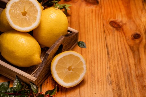A high angle closeup shot of lemons on a wooden surface - perfect for background