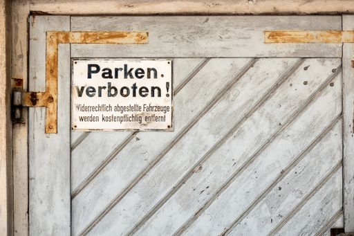 A closeup shot of a private no parking sign with german text