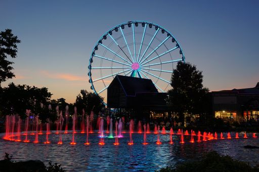 Evening on the Island in Pigeon Forge, Tennessee USA with the blue lights on the ferris wheel and red lights in the fountain illuminated.