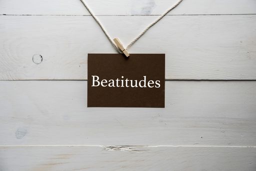 A closeup shot of a brown paper hanged on paper with Beatitudes written on it on a white background