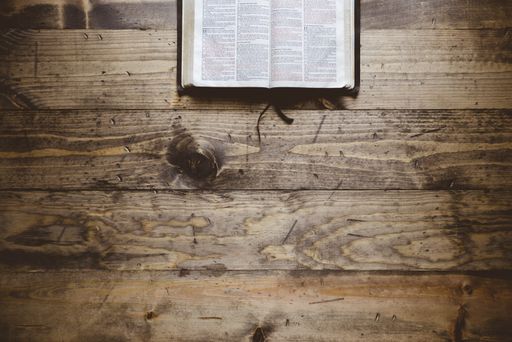 An overhead shot of an open book on a wooden surface