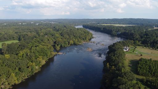 An aerial shot of Coosa river flowing between dense trees in Wetumpka, Alabama, Elmore County