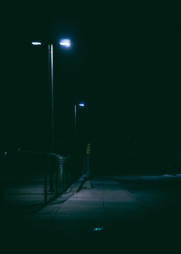 A vertical shot of a lighted street lamp during nighttime