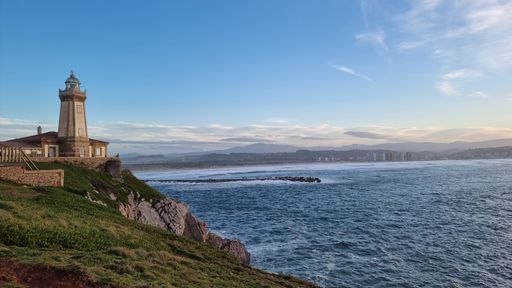 A distant view of the beautiful Faro de San Juan lighthouse at the coast in Asturias, Spain