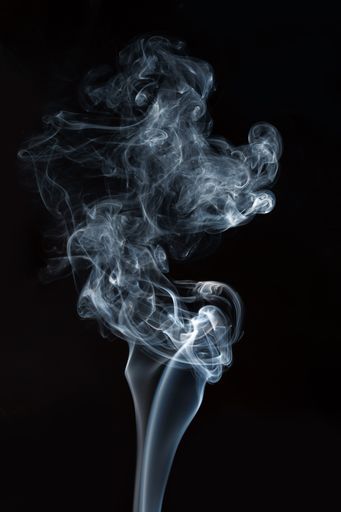 A vertical shot of smoke isolated on black background