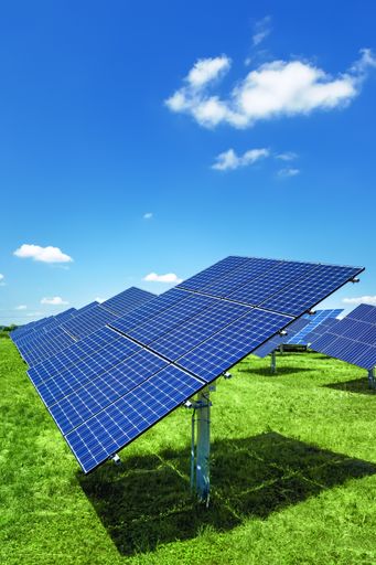 A vertical shot of solar panels in the field under a cloudy sky