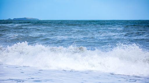A beautiful view of strong sea waves under a blue sky