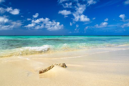 A panoramic view of Arashi Beach on the island of Aruba in the Caribbean with blue skies and white sand