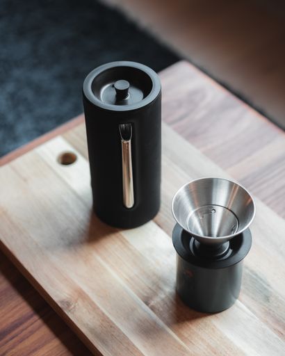 A closeup of coffee brewing gadgets on a wooden board