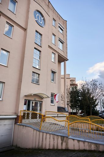 The front entrance of an apartment building with a Polish flag in the Stare Zegrze district, Poland