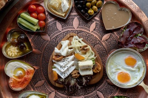 A top view of cooked eggs with cheese and sauce on a classic big dish