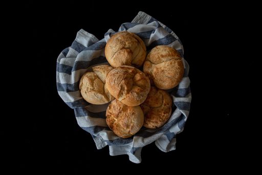 A closeup shot of bread rolls in home made blue striped cotton isolated on a black background