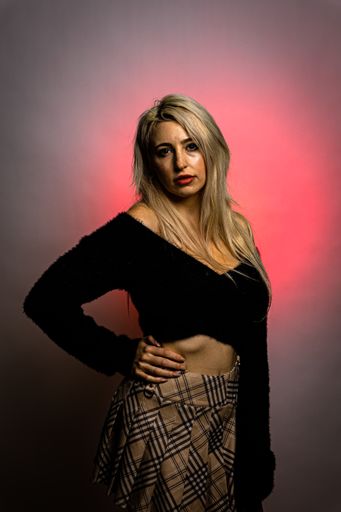 A portrait of a caucasian female posing for a photo in a studio