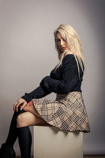 A portrait of a caucasian female posing for a photo in a studio