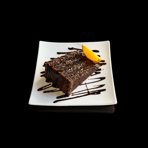 A high angle shot of a chocolate cake piece on a black background