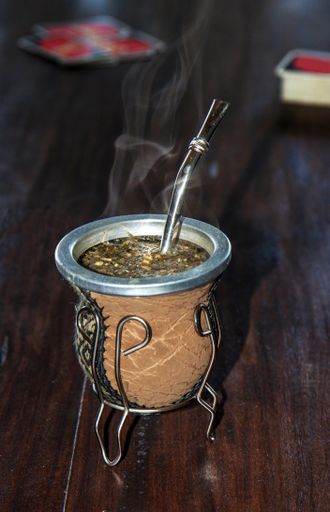 Hot 'mate' with straw or bombilla in traditional calabas, Argentina's national drink
