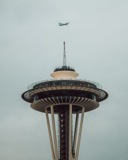 A plane flying over the Space Needle observation deck in Seattle, Washington