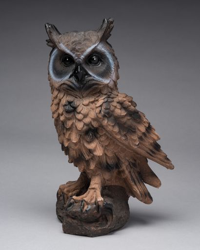 A vertical shot of an owl sculpture isolated on gray background