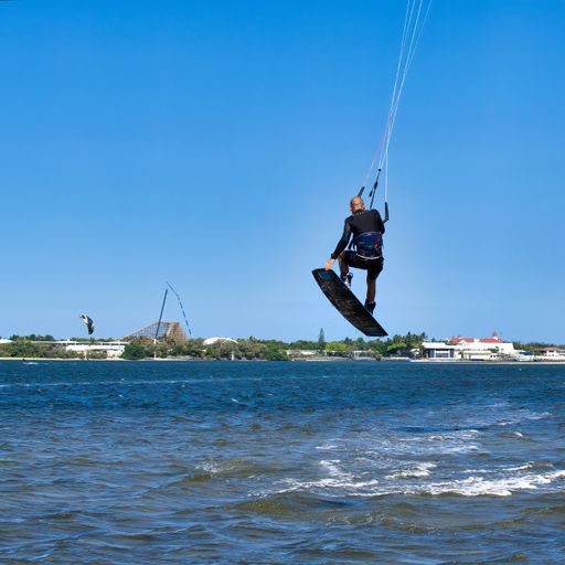 A square image of a kite surfer rising up from the water at Surfers Paradise, Australia