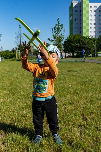 Young small two years old boy throwing a green foam plane at a park in the Orla Bialego area.