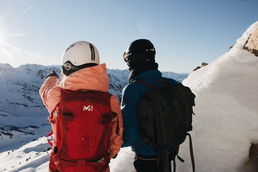 A closeup of two climbers enjoying the beautiful view of the snowy mountains.