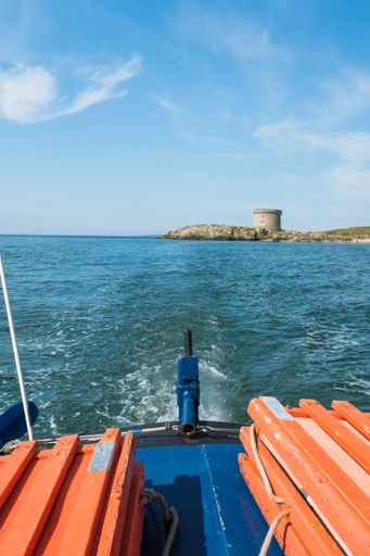 A vertical shot of the Martello tower in Howth, Ireland taken from a boat