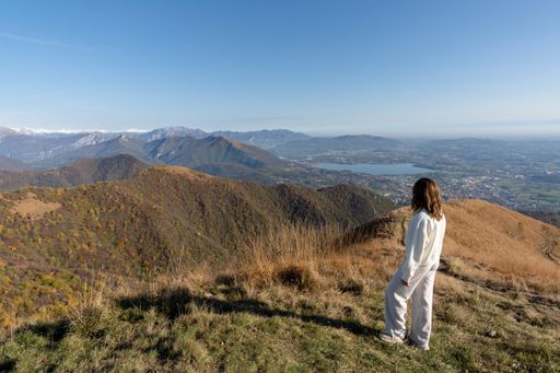 A Caucasian woman on a top of mountain admiring landscape of  Lago di Como, Italy