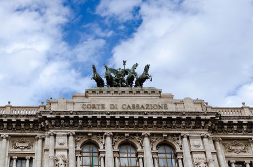 A low angle closeup of the writing and the bronze sculpture on top of of the Palace of Justice, Rome, Italy