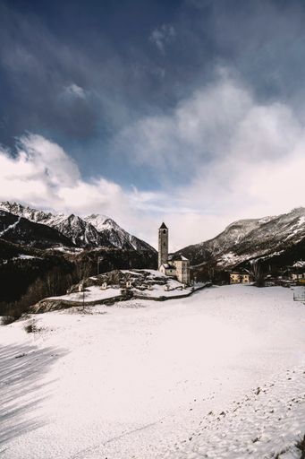 A vertical shot of a church in Rossura in Switzerland during a winter day