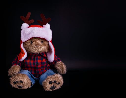 A closeup of a teddy bear with a black background
