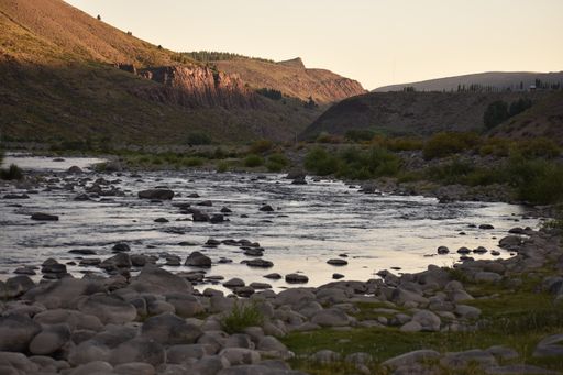 A river during sunset with rocky mountains in the background