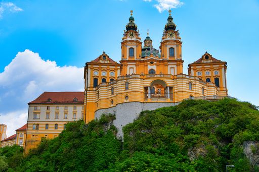 A mesmerizing view of the Benedictine abbey on the hill with dense greenery in Melk, Austria