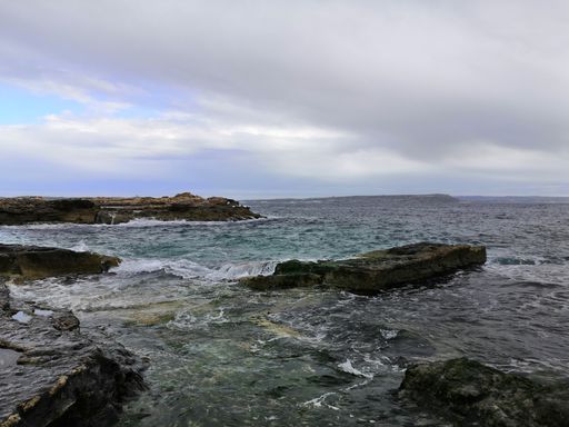 A beautiful view of rocky seashore under a cloudy sky