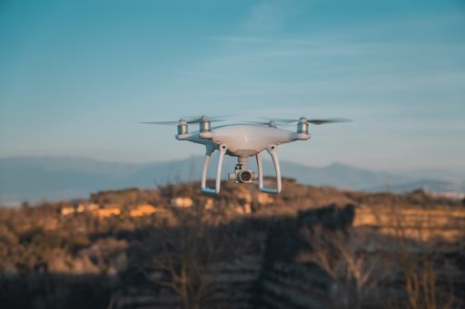 A big white drone in hovering with constructions in blurred background in Rome, Italy