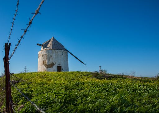 A historic windmill in the green field in Spain