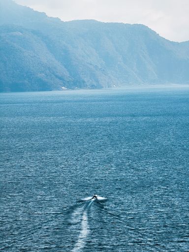 A mesmerizing view of high hills with dense greenery over the Lake Atitlan in Guatemala