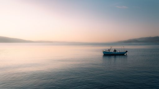 A scenic view of a person in a boat in the middle of a sea
