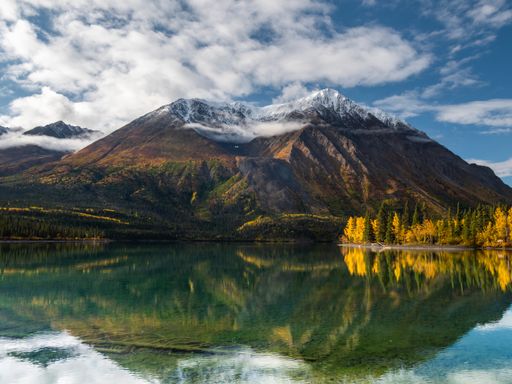 A scenic view of King's Throne peak and Katherine Lake in Yukon territory on an autumn day