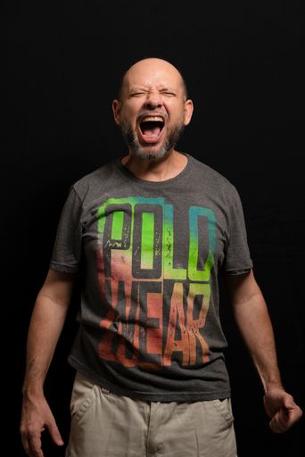 A portrait of a shouting man standing against a black background