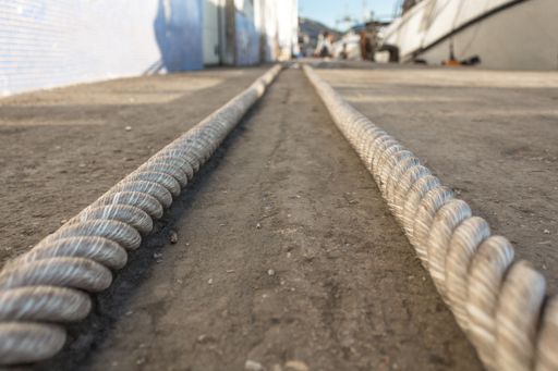 A selective focus shot of two thick ropes lying on the ground