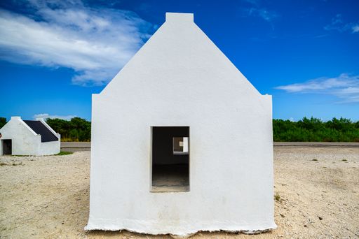 A view of the slave houses on Bonaire in the Caribbean with a blue sky and turquoise sea