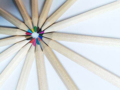 A macro view of sharp color pencils put close to each other on the white paper