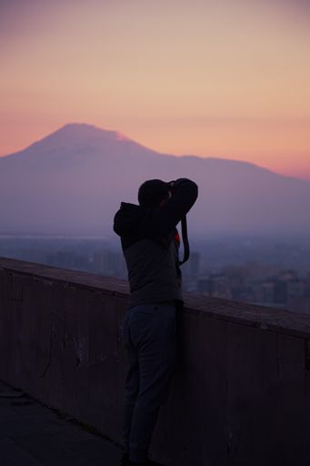 A photographer taking pictures in Cascade monument symbol of Armenia Mount Ararat at scenic sunset