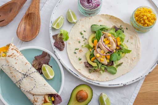A top view of fresh tortilla wraps on a plate with ingredients