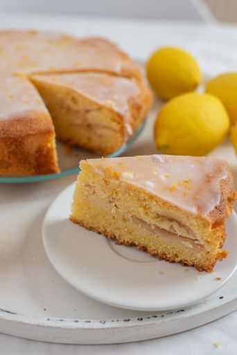 A closeup shot of homemade sliced lemon sponge cake on a white plate