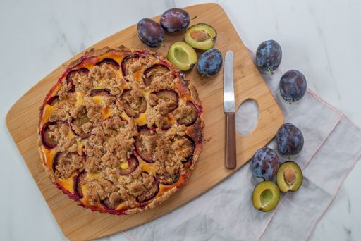 A top view of a sweet homemade plum crumble pie on a table
