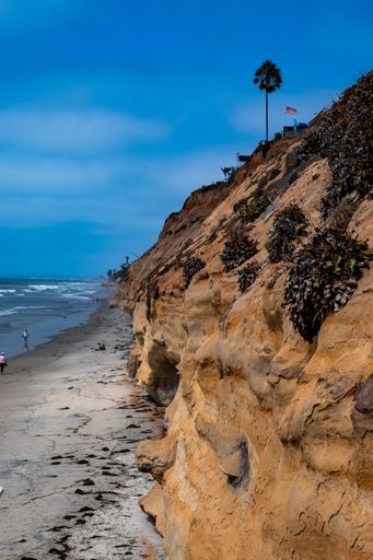 A vertical shot of sheer cliff and blue seas