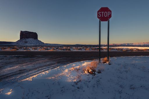A beautiful view of a snowy field with a rock formation in the background