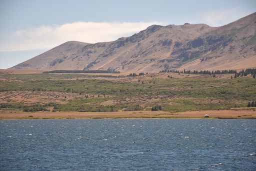 A beautiful shot of a calm lake surrounded by mountains and hills